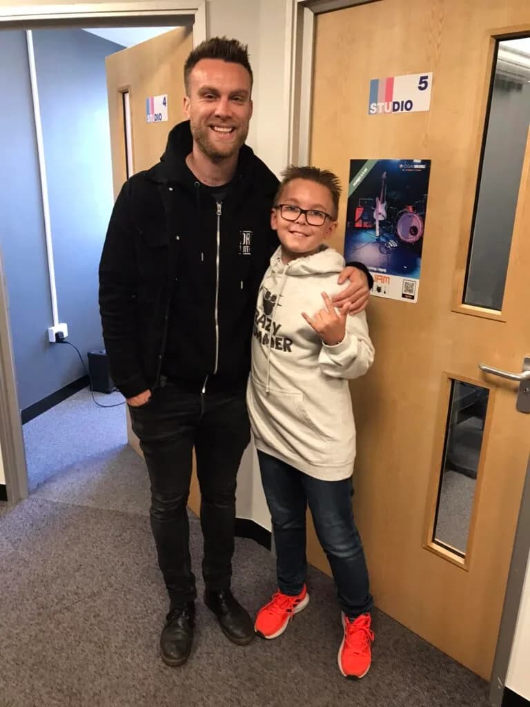 Student and teacher doing a rock on sign and hugging after an exam.