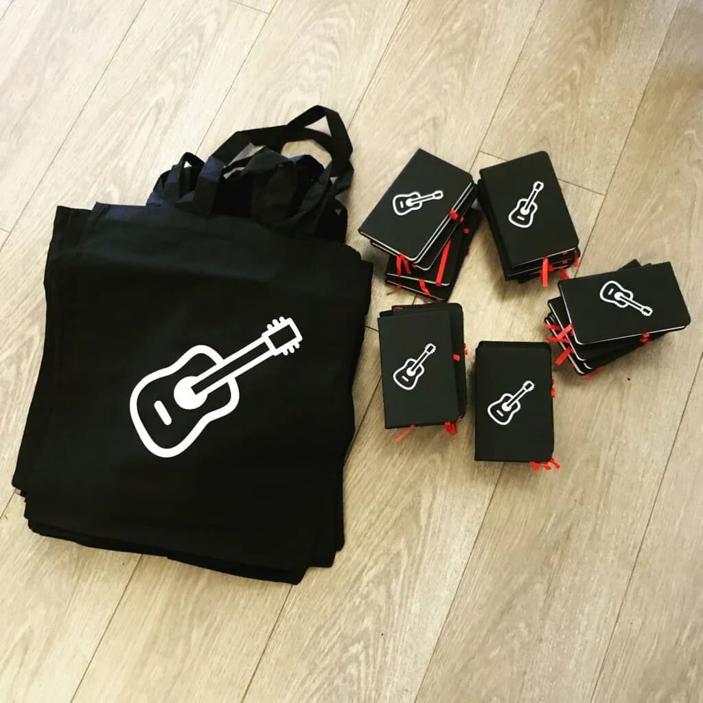 Guitar-themed tote bag and practice notebook.