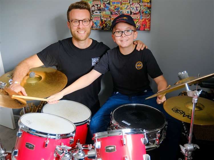 Alex Lewis with a student smiling after Grade 8 drum results at 12 years old