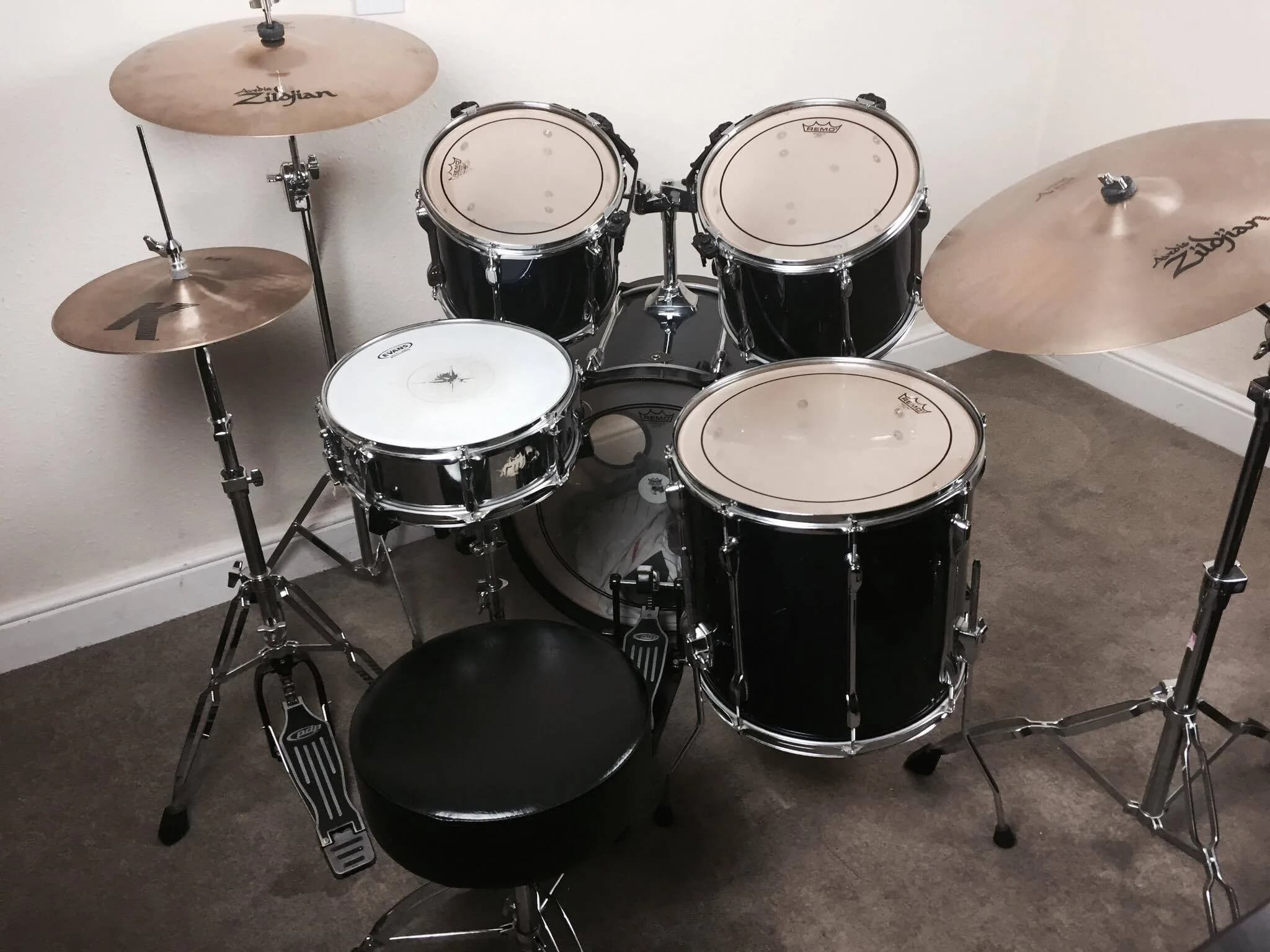 Complete beginner drum kit with cymbals, toms, snare, and stool, essential drum equipment for beginners.