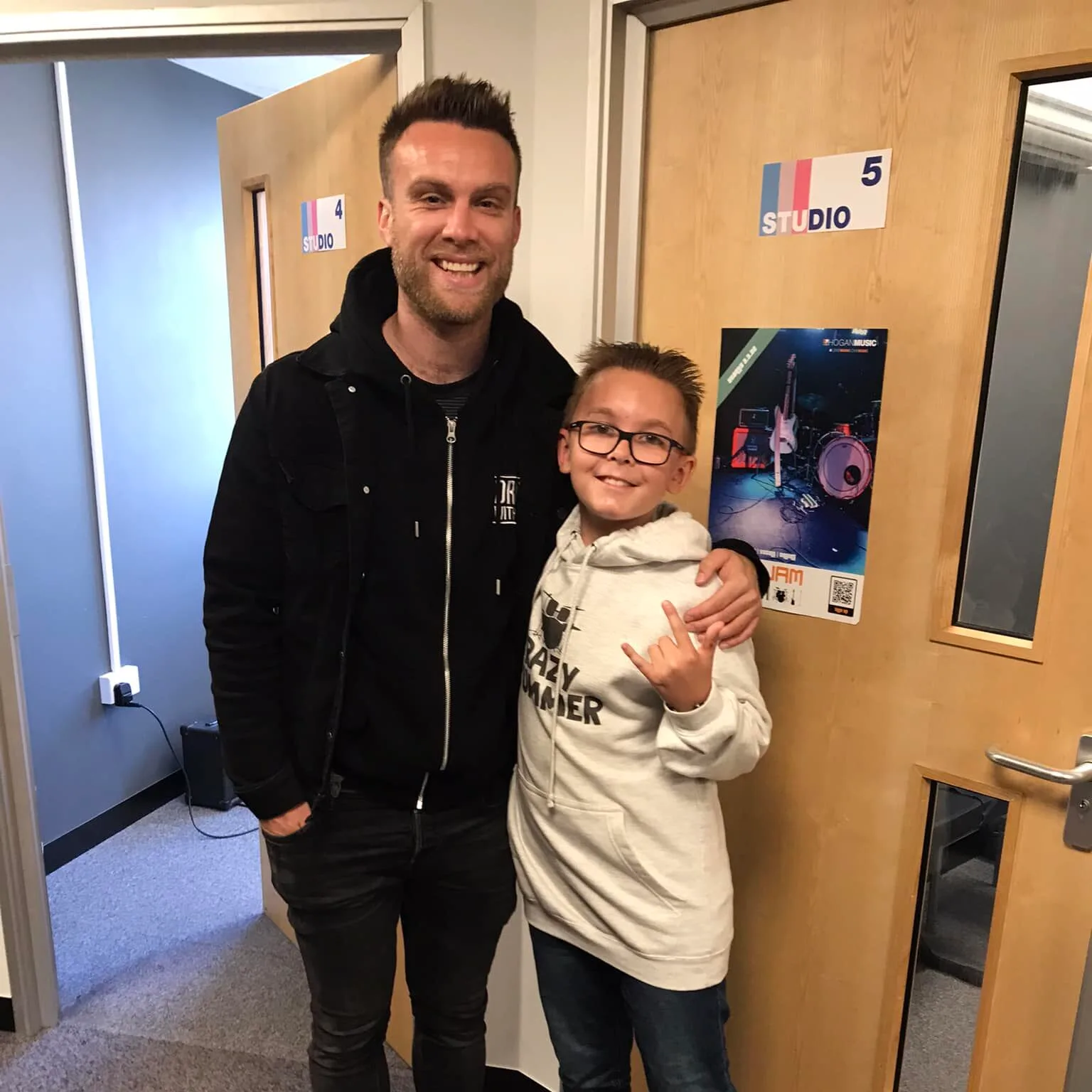 Drum tutor and student celebrating after a successful exam, both smiling happily.