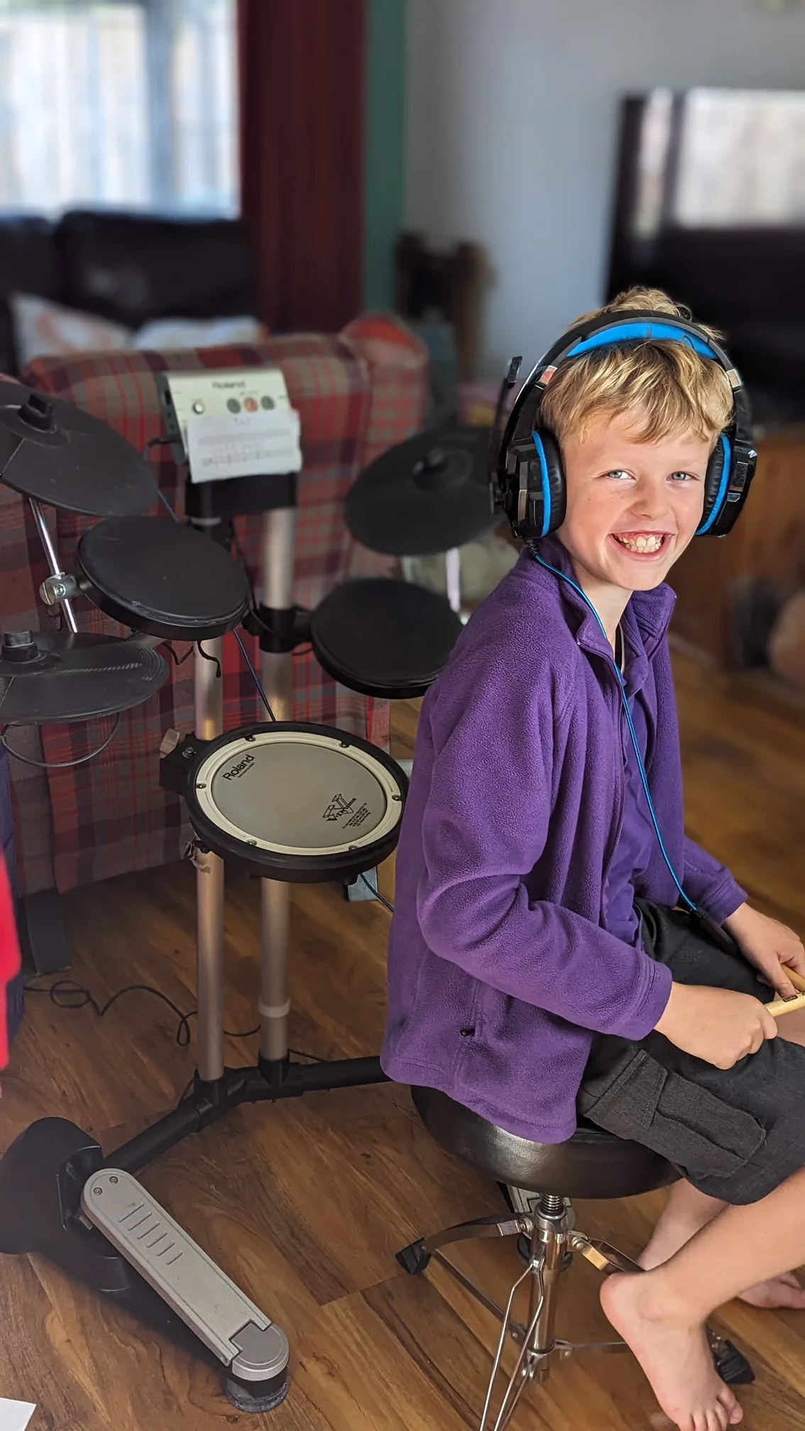 Child practicing drums in a quiet, distraction-free space.