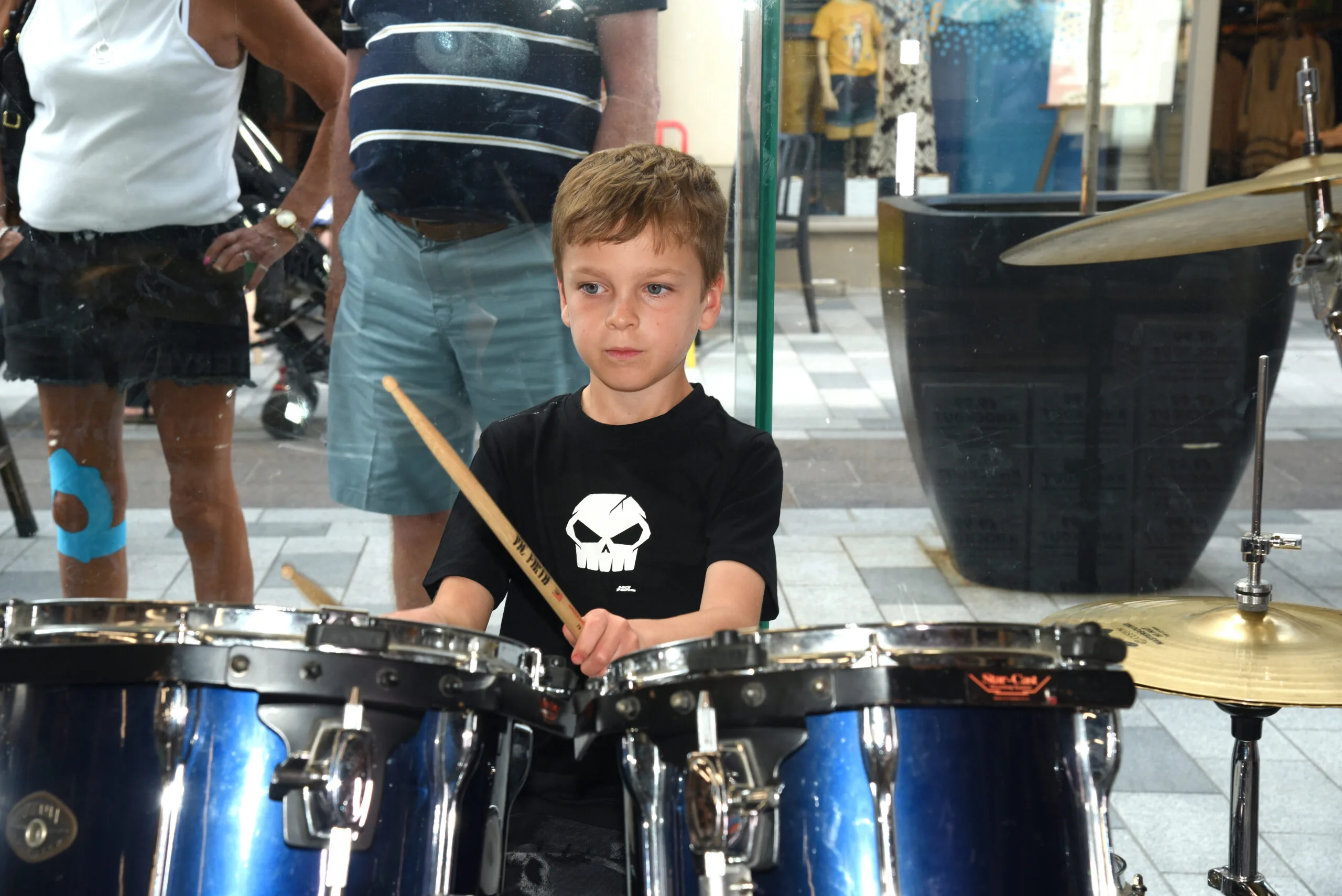 Child engaged in drum practise for kids, demonstrating focus and concentration while playing the drums.